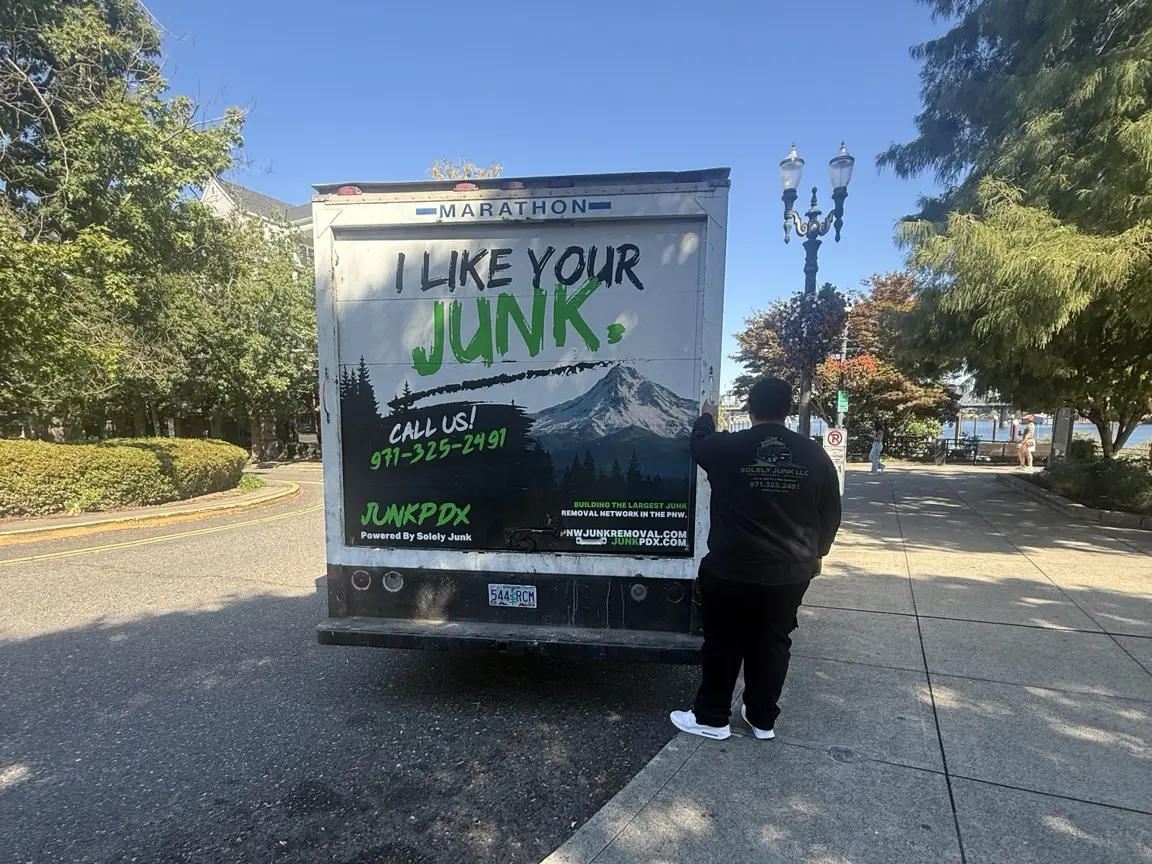 A JunkPDX crew member beside the local junk removal truck at Portland’s waterfront