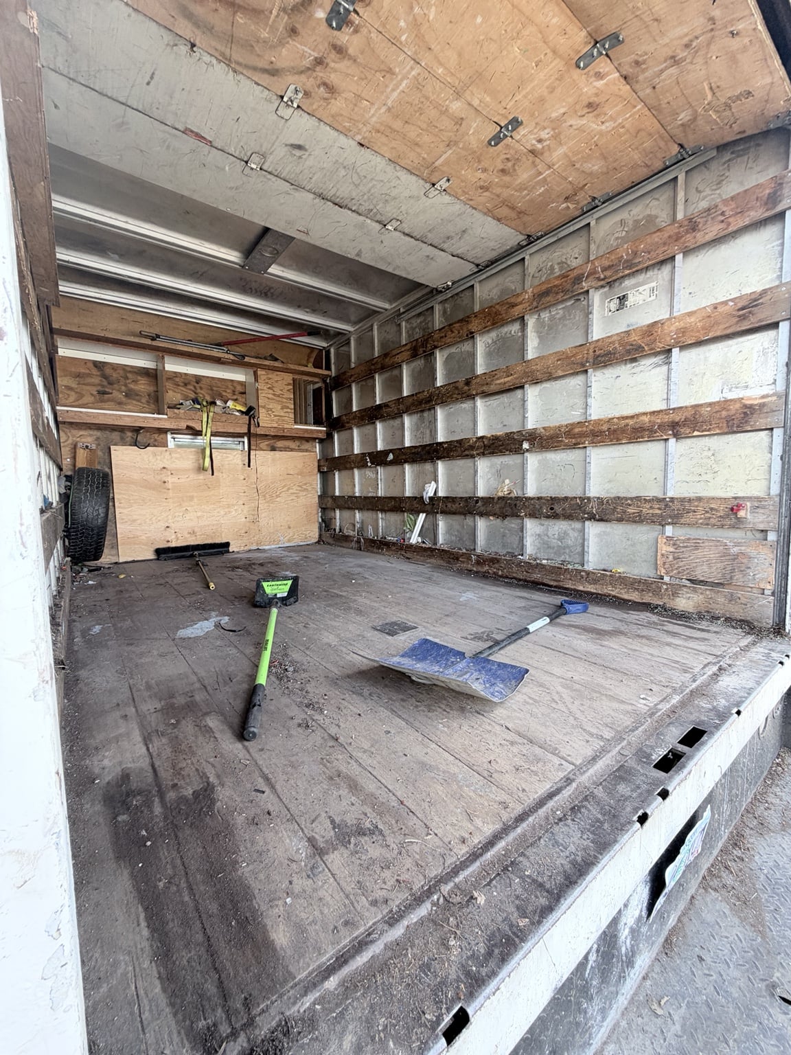 Inside JunkPDX’s box truck, showing the cargo floor, walls and loading tools