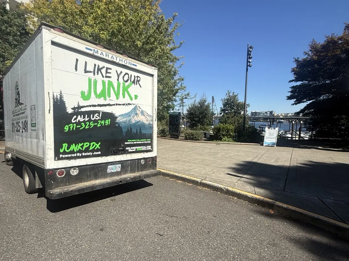 JunkPDX truck with green, white and black rear-door branding near Portland’s waterfront